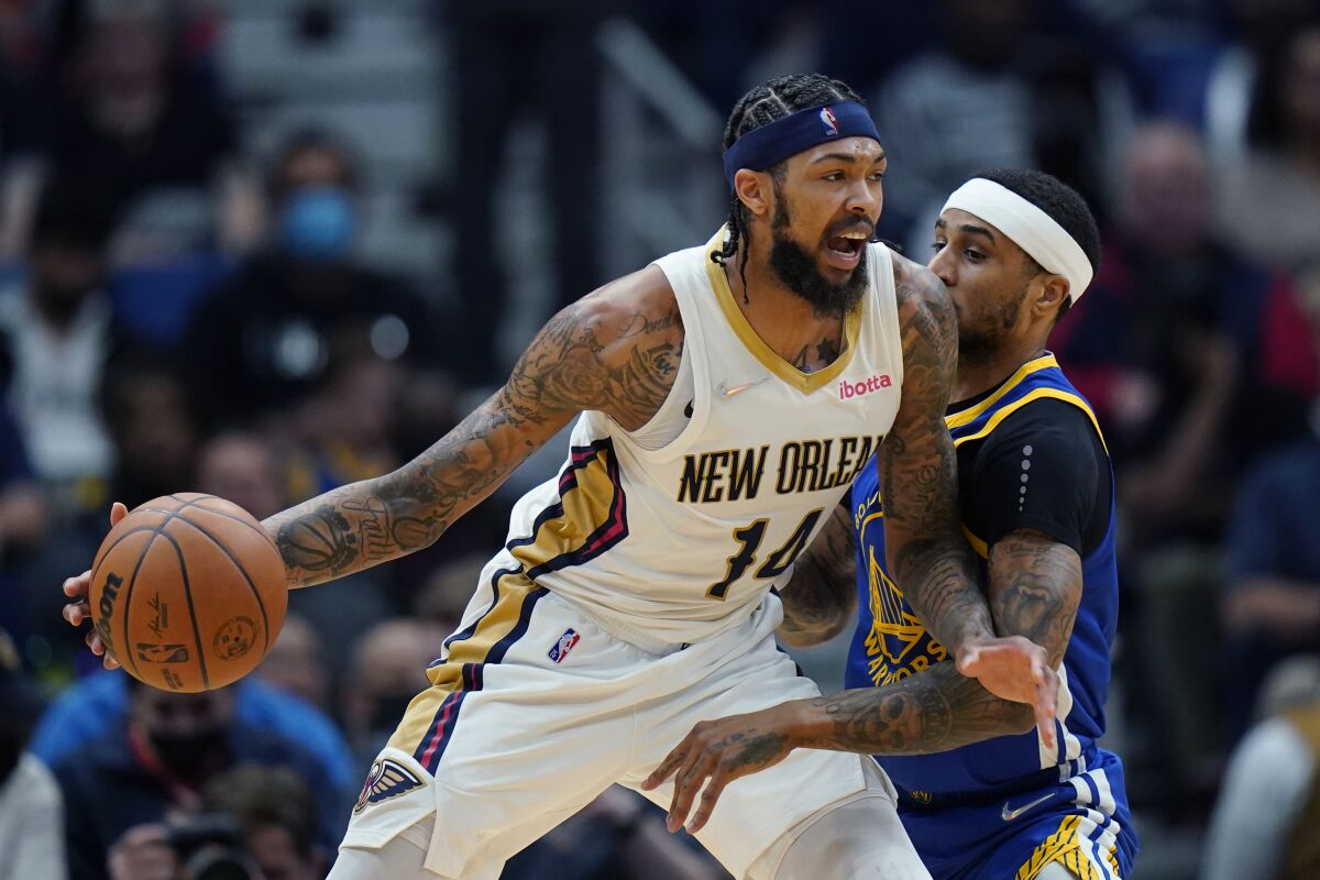 New Orleans Pelicans forward Brandon Ingram (14) drives to the basket against Golden State Warriors guard Gary Payton II in the first half of an NBA basketball game in New Orleans, Thursday, Jan. 6, 2022. (AP Photo/Gerald Herbert)