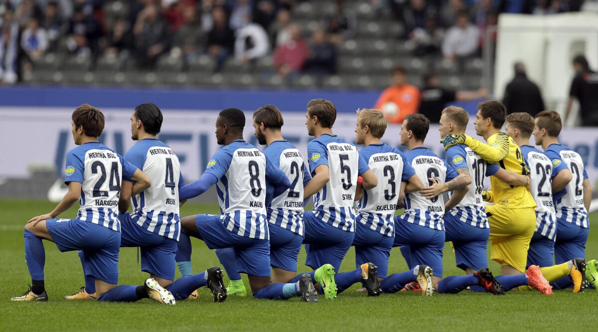 Players of Berlin kneel down prior to the German Bundesliga soccer match between Hertha BSC Berlin and FC Schalke 04 in Berlin, Germany, Saturday, Oct. 14, 2017. Hertha Berlin nodded to social struggles in the United States by kneeling before its Bundesliga game at home to Schalke on Saturday. Herthaâ€™s starting lineup linked arms and took a knee on the pitch, while coaching staff, officials and substitutes took a knee off it. The action was intended to show solidarity with NFL players who have been demonstrating against discrimination in the US by kneeling, sitting or locking arms through the anthem before games. (AP Photo/Michael Sohn)