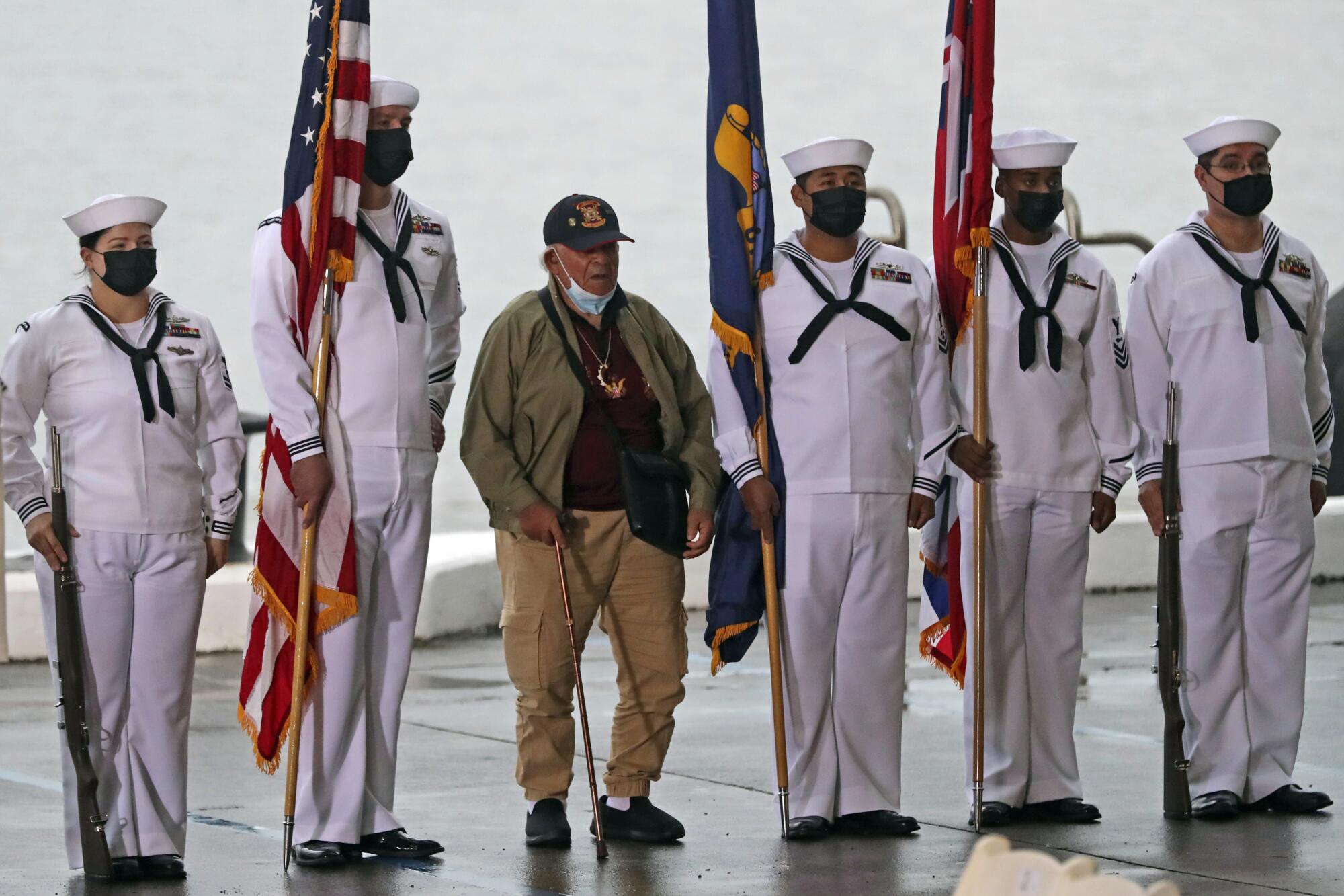 A veteran stands with the military color guard before the Pearl Harbor anniversary ceremony 