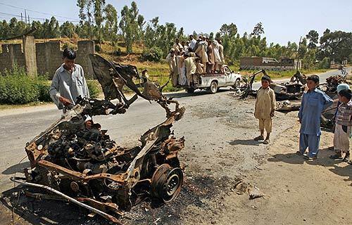 A resident of Ambela, in Buner district, looks over the remains of a car destroyed by fire from a Pakistani tank in late April; one passenger was killed. Ambela was one of the first towns the Pakistani military entered in the operation against Taliban fighters in the northwest and residents have returned only to find crippled infrastructure, a lack of drinking water and ruined crops.
