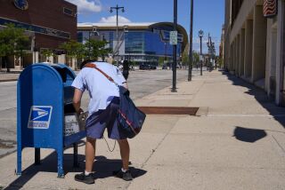 FILE - A postal worker empties a box near the Fiserv Forum on Aug. 18, 2020, in Milwaukee. The U.S. Postal Service is replacing tens of thousands of antiquated keys used by postal carriers and installing thousands of high-security collection boxes to stop a surge in robberies and mail thefts, officials said Friday, Friday, May 12, 2023. (AP Photo/Morry Gash, File)