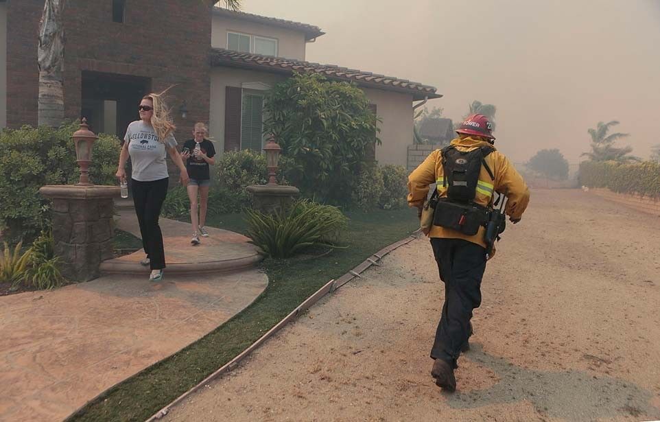 A Ventura County firefighter dashes to protect homes on Via Santa Ana as the Springs fire rages in Newbury Park.