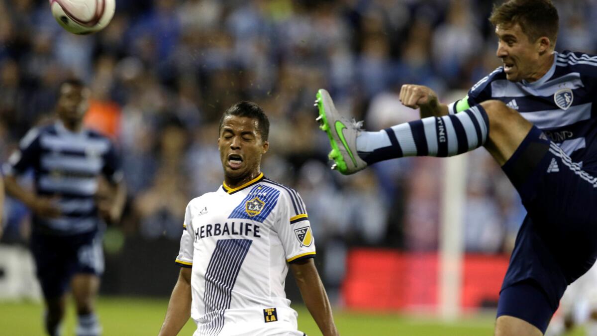 Galaxy forward Giovani Dos Santos (10) stops before colliding with Sporting KC defender Matt Beslerin the first half Sunday.