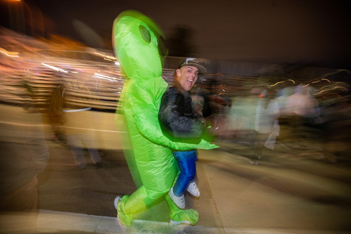 A jogger wears an alien costume.