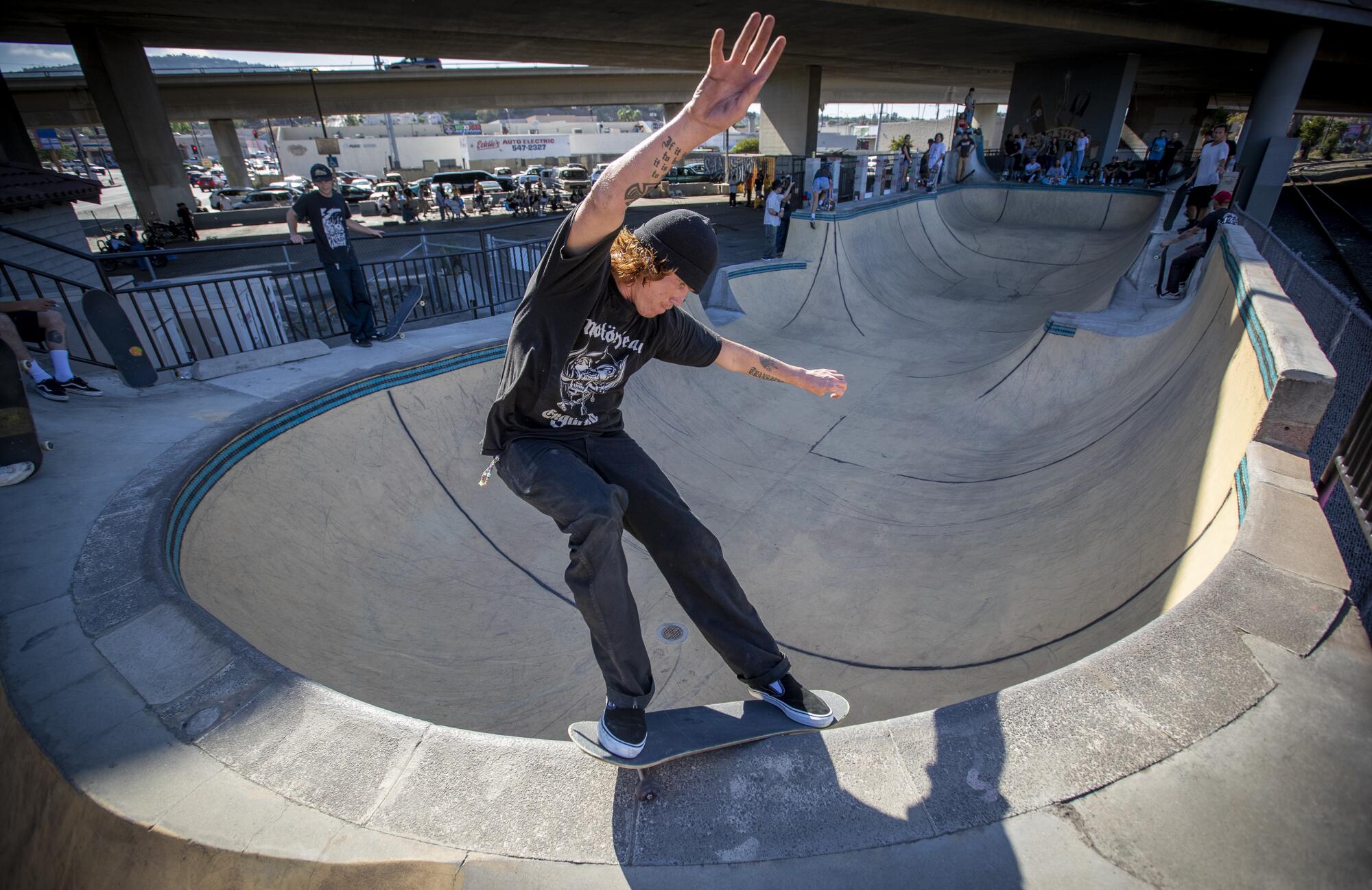 Jordan Toledo of San Pedro slides across the coping of the bowl at the Channel Street Skatepark.