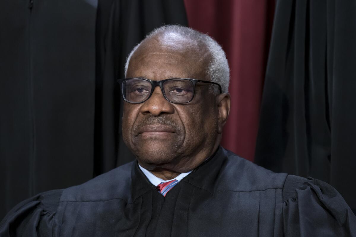 Associate Justice Clarence Thomas posing in judicial robes