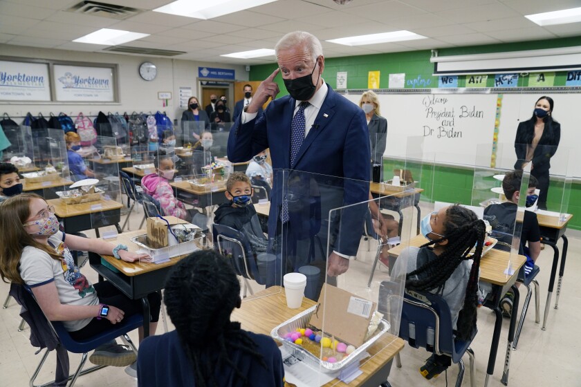 In this May 3, 2021, photo, President Joe Biden gestures as he talks to students during a visit to Yorktown Elementary School, in Yorktown, Va., as first lady Jill Biden watches. Biden has met his goal of having most elementary and middle schools open for full, in-person learning in his first 100 days. (AP Photo/Evan Vucci)