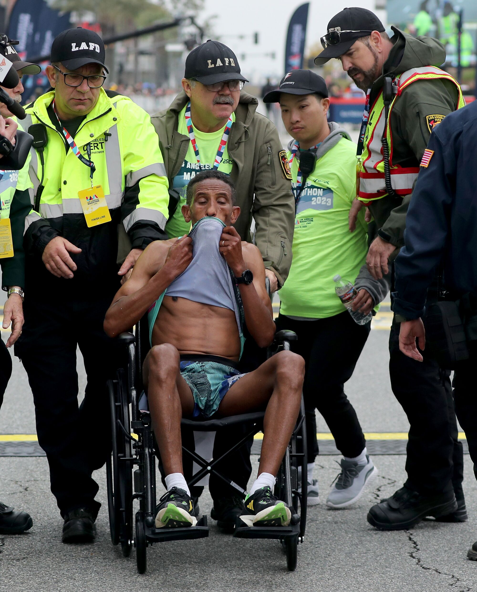 Yemane Tsegay of Ethiopia is taken away in a wheelchair after collapsing at the finish line.