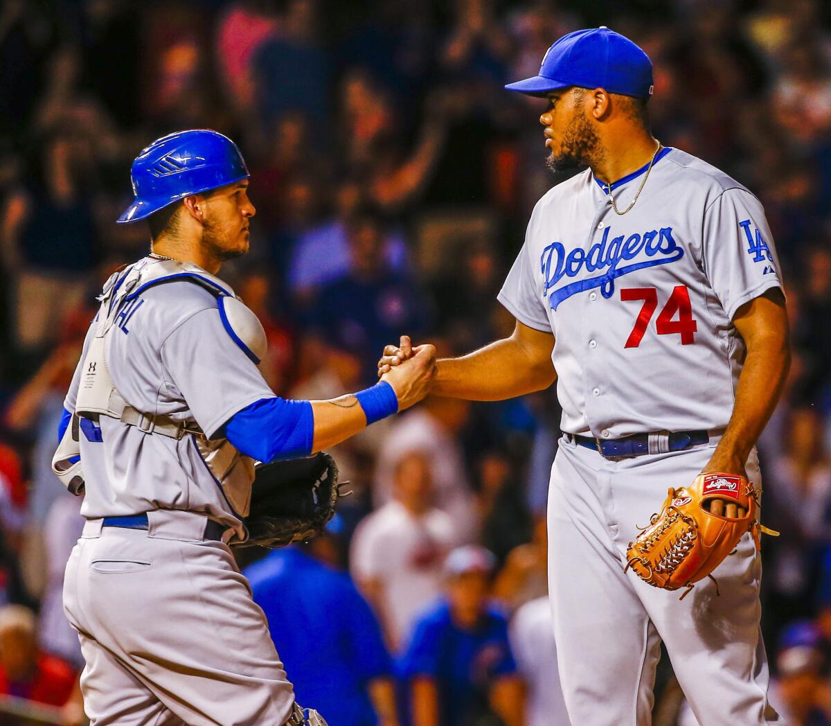 Closer Kenley Jansen and catcher Yasmani Grandal celebrate after getting the final out of a game Wednesday to give the Dodgers a 5-2 victory over the Chicago Cubs at Wrigley Field.