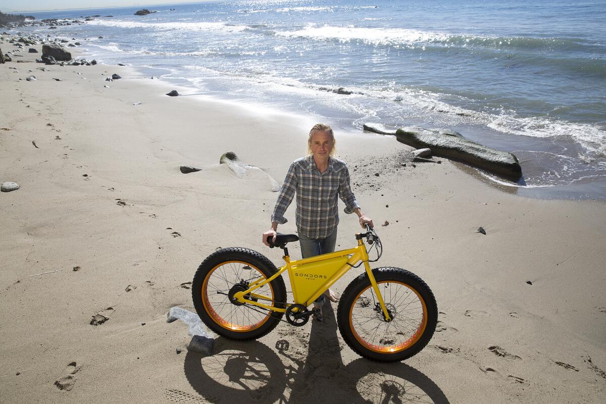 MALIBU, CA - FEBRUARY 123 2015 Storm Sondors with his electric eBike on the beach at his home February 13, 2015 in Malibu. Sondors is a Malibu surfer and successful businessman who struggles with Aspergers Syndrome. (Brian van der Brug / Los Angeles Times)