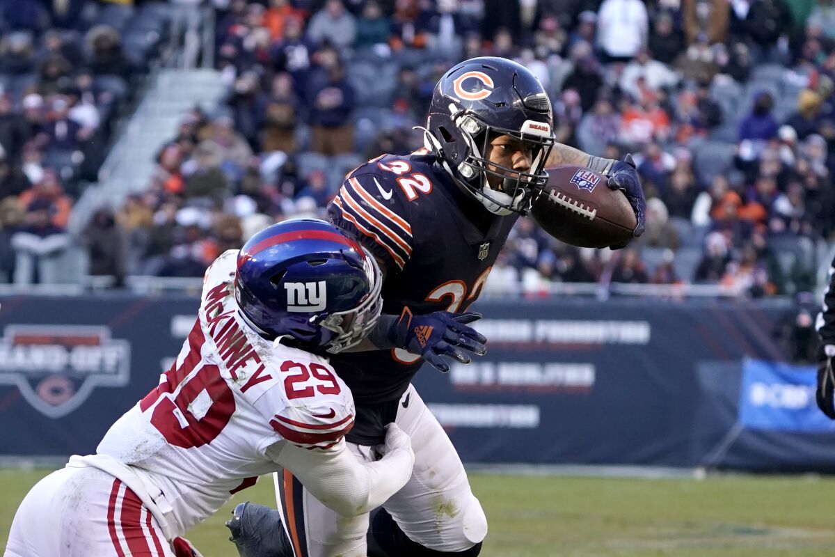 Chicago Bears running back David Montgomery (32) carries the ball as New York Giants free safety Xavier McKinney makes the tackle during the second half of an NFL football game Sunday, Jan. 2, 2022, in Chicago. The Bears won 29-3. (AP Photo/David Banks)