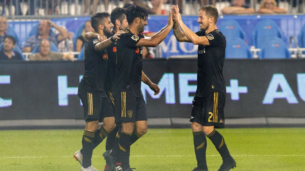LAFC's Carlos Vela, left, is congratulated by Jordan Harvey after scoring his team's fourth goal against Toronto FC during the second half on Sept. 1 in Toronto.