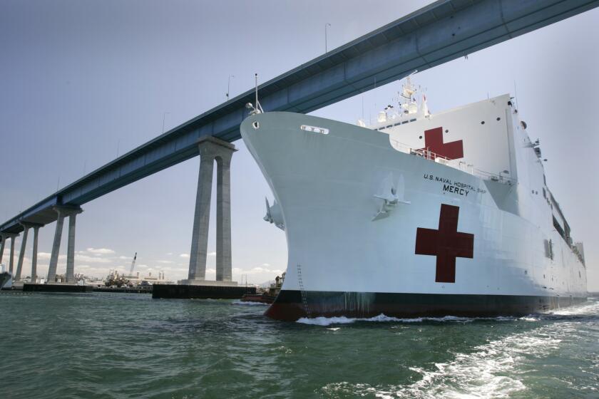 U.S. Naval Hospital Ship Mercy steams beneath the Coronado Bridge shortly after setting sail from the U.S. Naval Base San Diego.
