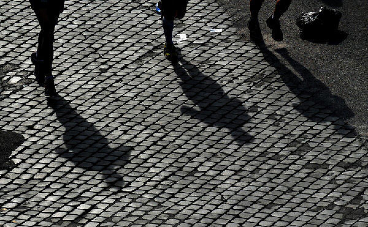 A picture shows shadows of runners taking part in the 19th Rome Marathon on Sunday. The marathon course came close to the Vatican, where Pope Francis was delivering his first Sunday Angelus blessing.