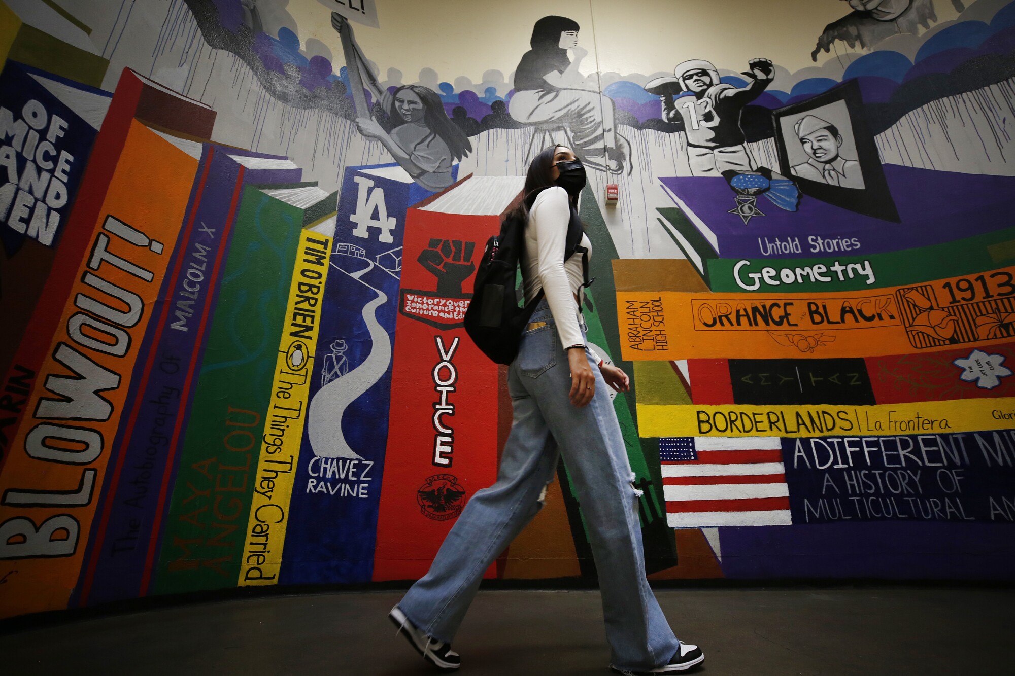 A student walks past a mural