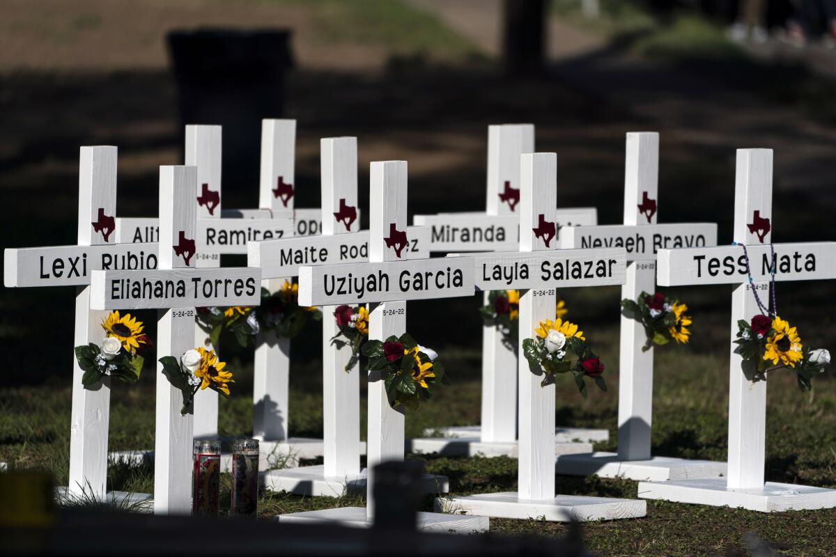 ARCHIVO - Cruces con los nombres de víctimas de la masacre en la Escuela Primaria Robb yacen frente a ésta el 26 de mayo