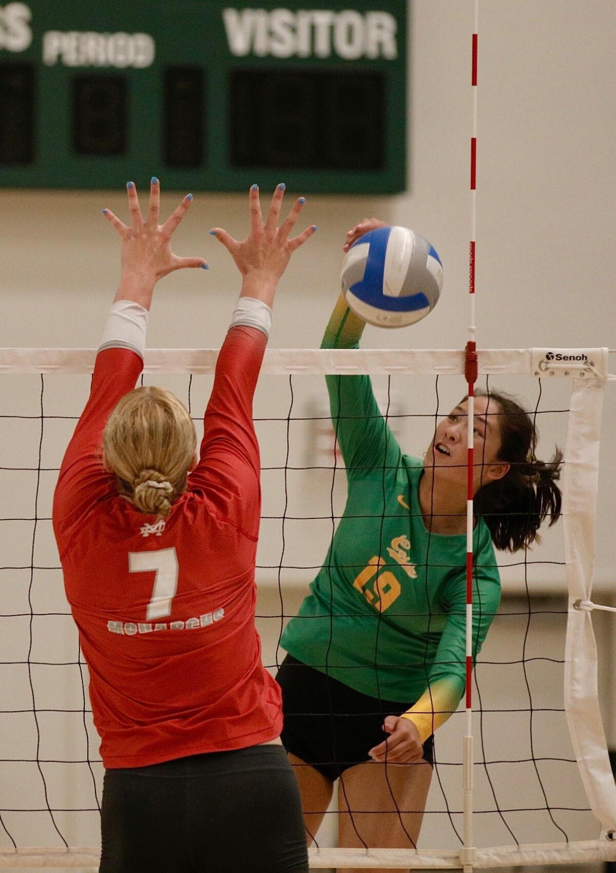 Sophomore outside hitter Simone Roslon of Mira Costa High spikes over Mater Dei’s Julia Kakkis.