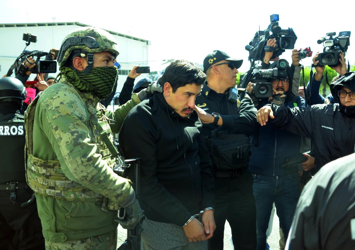 Óscar Andrés Flores (c), alias el Lunares, es conducido a un vehículo blindado luego de su arribo a Ciudad de México (México). Lunares, uno de los excéntricos líderes del cártel Unión Tepito, fue detenido por la Secretaría Seguridad capitalina y marinos mexicanos. EFE/ Mario Guzmán/Archivo
