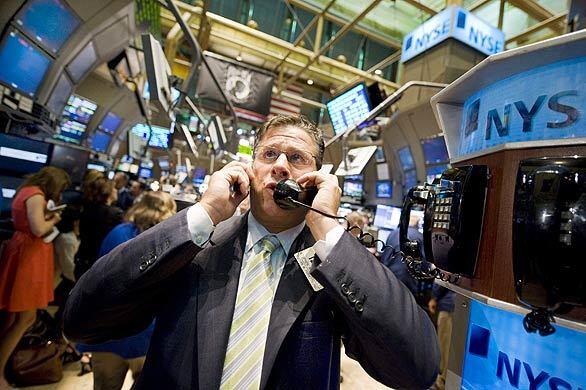 Trader Steve Ferretti uses two phones as he works on the floor of the New York Stock Exchange. Stocks staged a partial rebound early today after their biggest sell-off in years, though financial markets remained troubled a day after lawmakers rejected a $700-billion rescue plan for the financial sector.