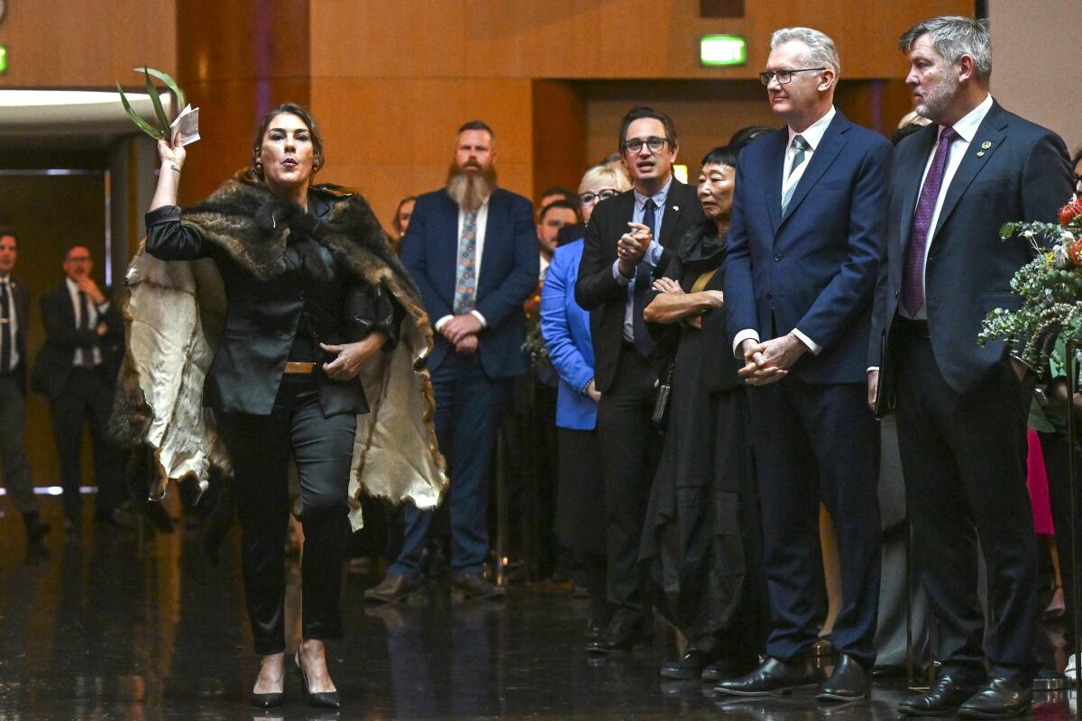 An Australian senator disrupts proceedings as others watch.