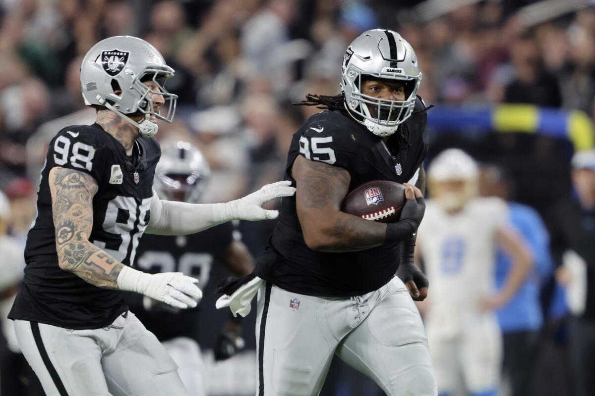 Raiders defensive tackle John Jenkins runs for a touchdown while a teammate is nearby.