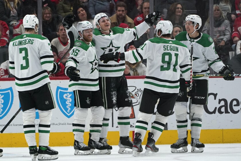 Dallas Stars left wing Roope Hintz, center, celebrates scoring during overtime in an NHL hockey game against the Detroit Red Wings Friday, Jan. 21, 2022, in Detroit. The Stars won 5-4. (AP Photo/Paul Sancya)