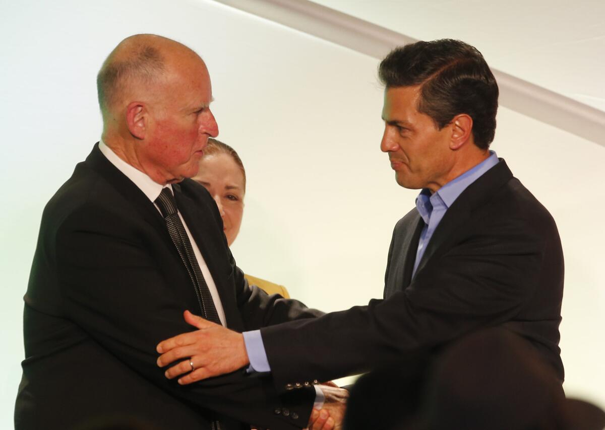 California Gov. Jerry Brown, left, greets Mexican President Enrique Peña Nieto during a meeting with Mexican American community leaders and others in Los Angeles on Monday.