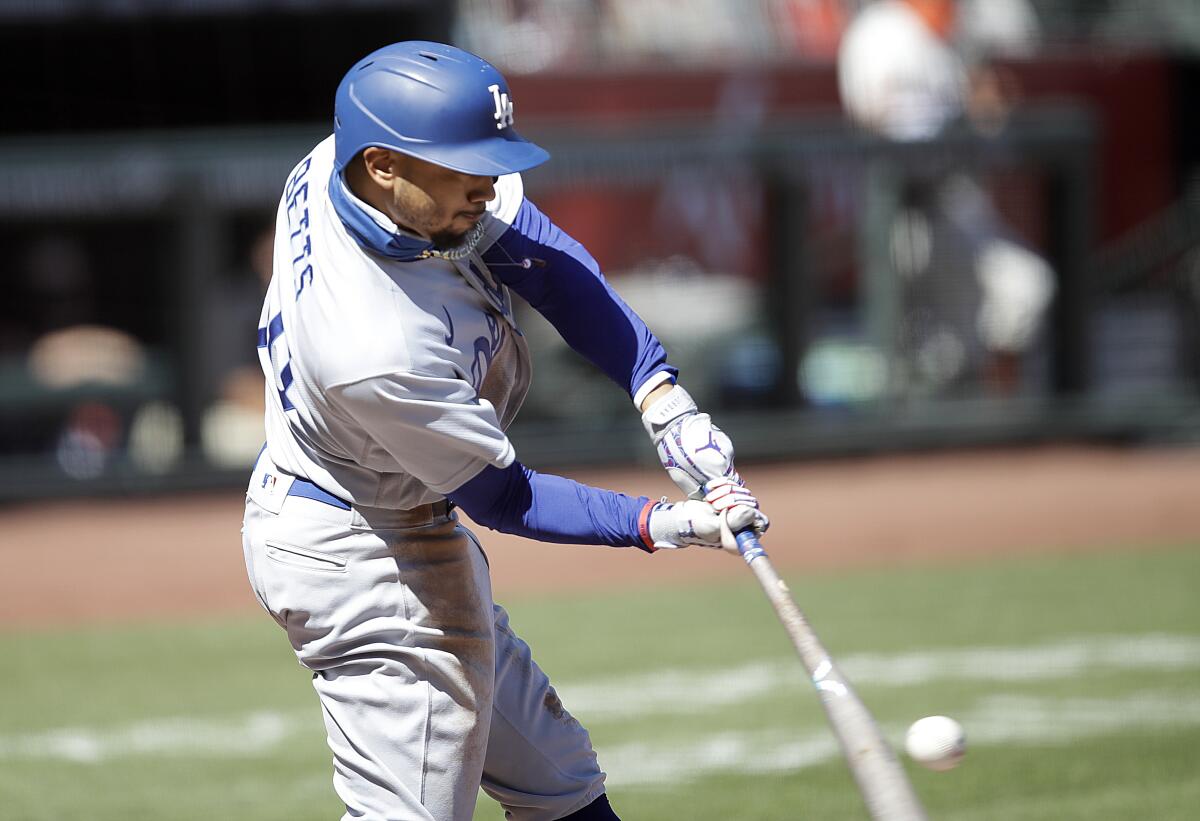 Dodgers right fielder Mookie Betts hits a single against the Giants.