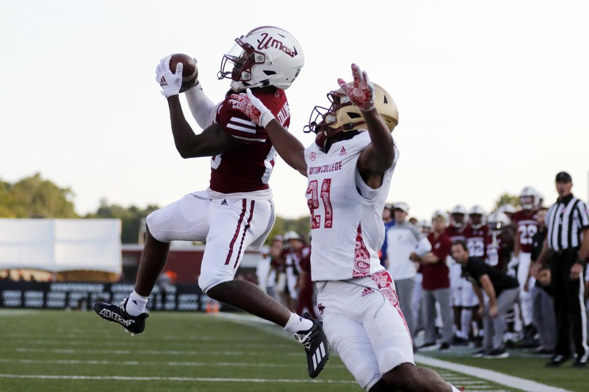 Massachusetts wide receiver Eric Collins (80) makes a touchdown catch against Boston College defensive back Josh DeBerry (21) during the second half of an NCAA college football game, Saturday, Sept. 11, 2021, in Amherst, Mass. (AP Photo/Michael Dwyer)