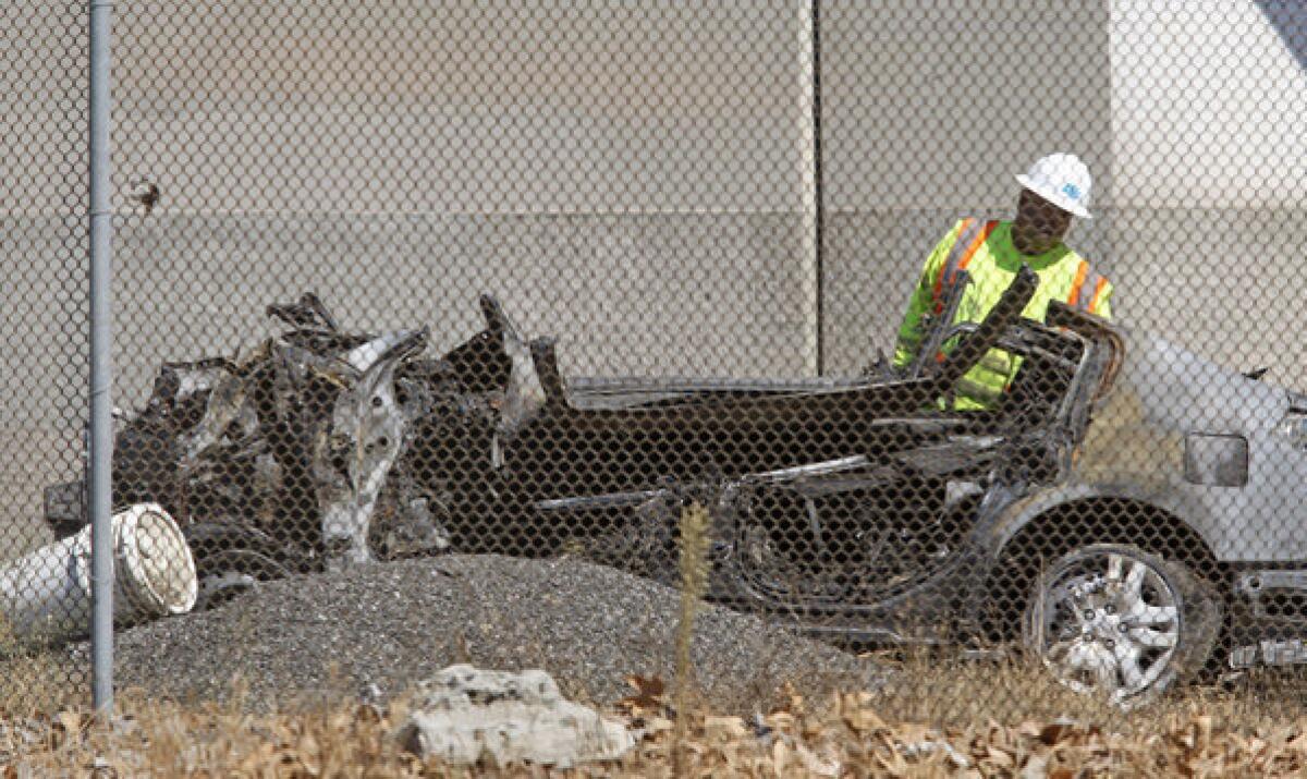 A workman examines the burned-out Nissan wreckage of a crash that killed five young people. The driver had more than twice the legal limit of alcohol in his system at the time, a coroner's report determined.