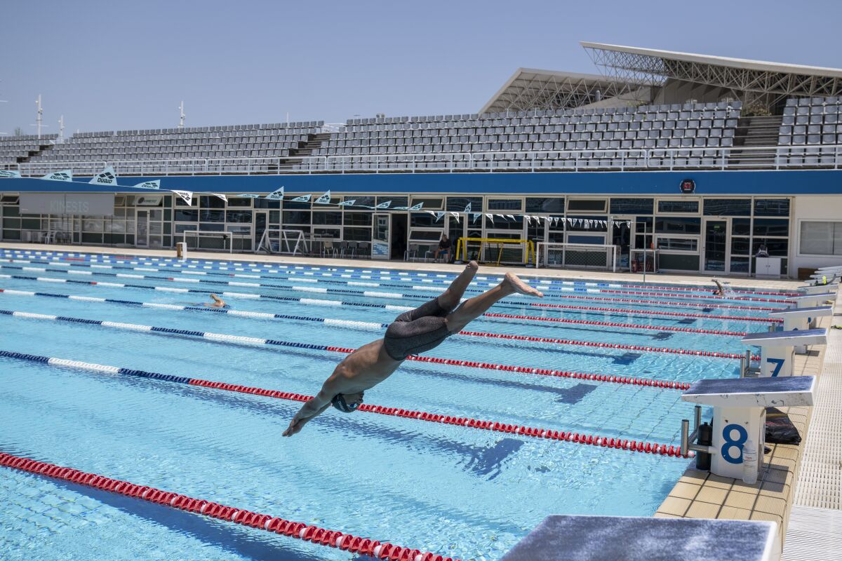 Syrian refugee Ibrahim al-Hussein, an amputee swimmer who lost his leg during the war in Syria, dives during a training at the Olympic Aquatic Centre, in Athens, on Wednesday , June 30, 2021. Ibrahim al-Hussein will be part of a Refugee Paralympic Team for the Tokyo 2020 Paralympic Games as the International Paralympic Committee announce Wednesday. (AP Photo/Petros Giannakouris)