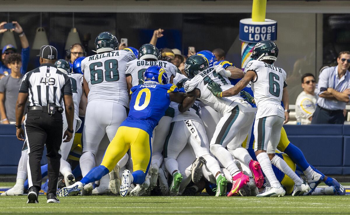 Philadelphia Eagles players push quarterback Jalen Hurts over the goal line against the Rams at SoFi Stadium.