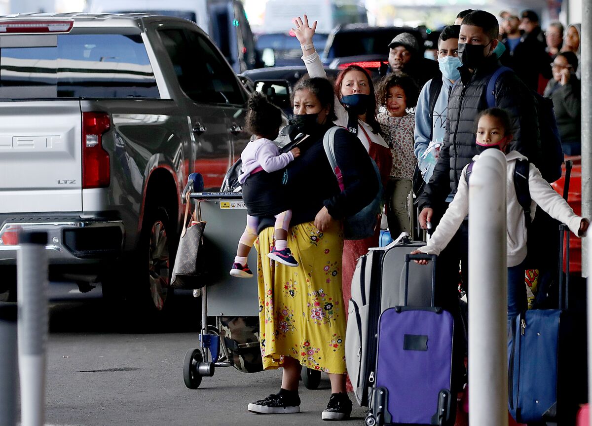 A mass of people lines a curb awaiting transportation at LAX.