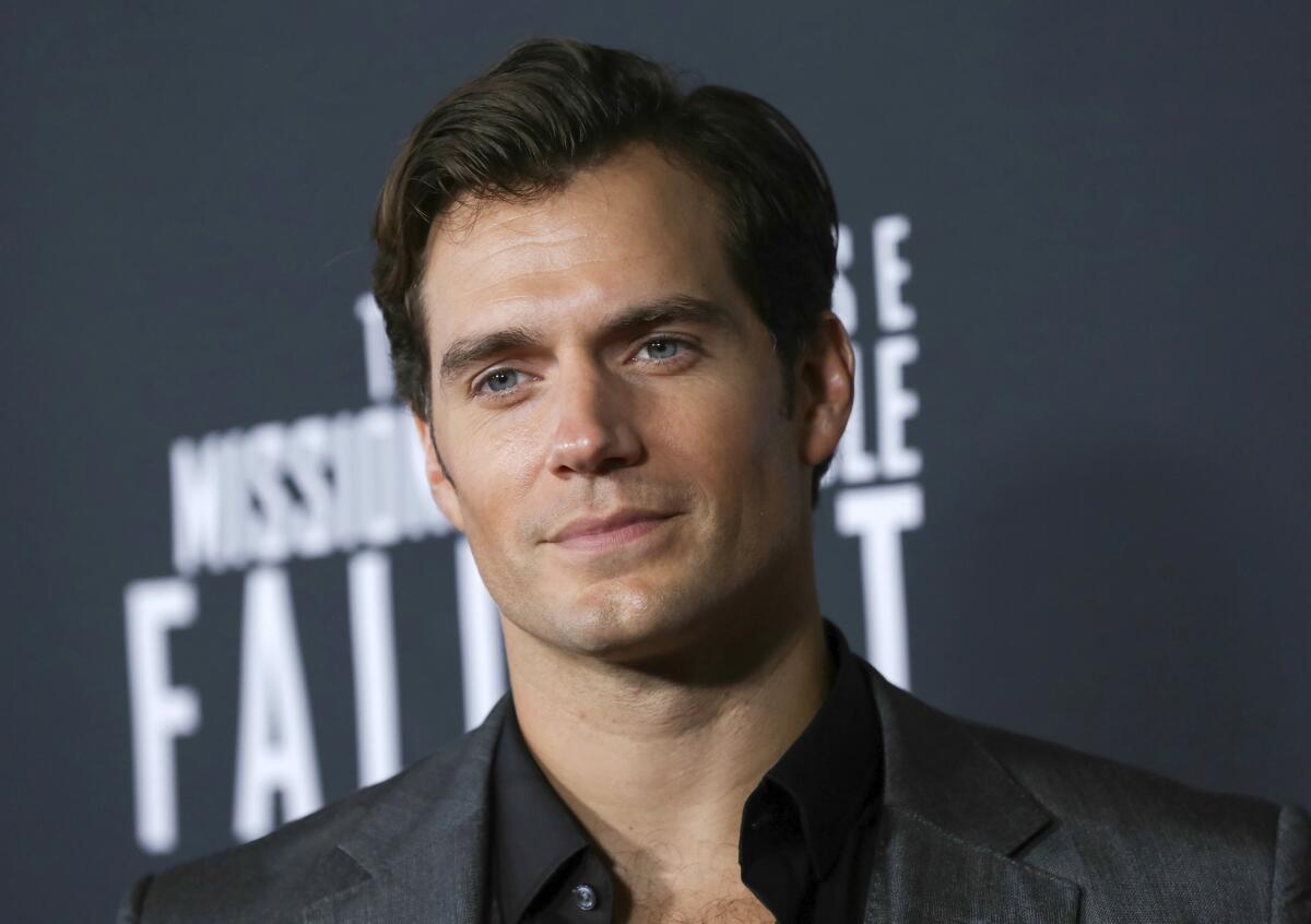 A man in a suit jacket poses at a movie premiere