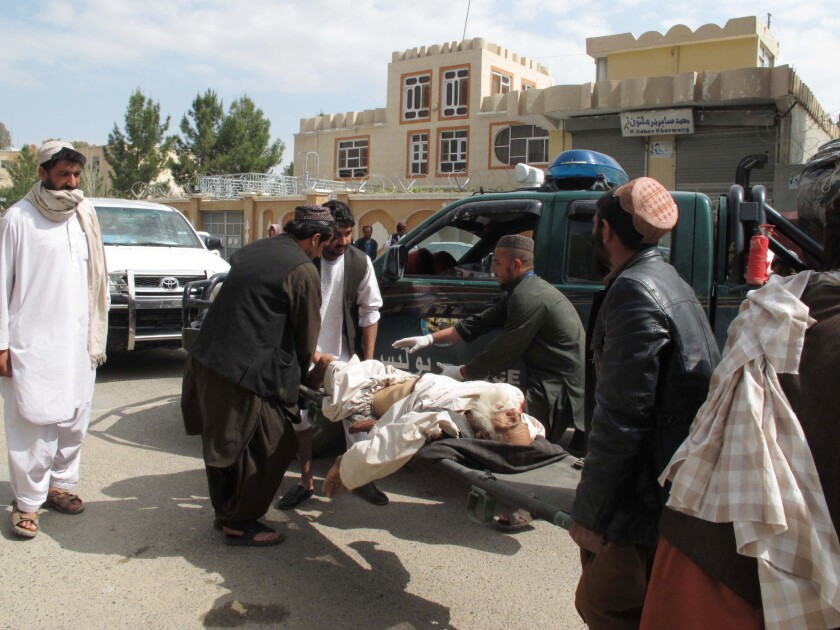 A wounded man receives aid at the site of a car bombing in Lashkar Gah, Afghanistan, on Wednesday.