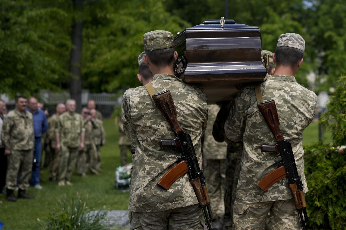 Ukrainian servicemen carry the coffin with the remains of Army Col. Oleksander Makhachek during his funeral in Zhytomyr, Ukraine, Friday, June 3, 2022. According to combat comrades Makhachek was killed fighting Russian forces when a shell landed in his position on May 30. (AP Photo/Natacha Pisarenko)