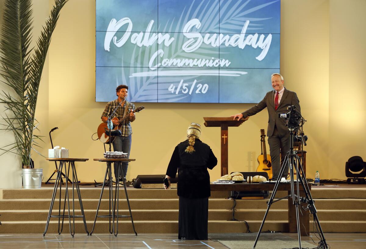 People on stage with a sign that says "Palm Sunday Communion, 4/5/20"