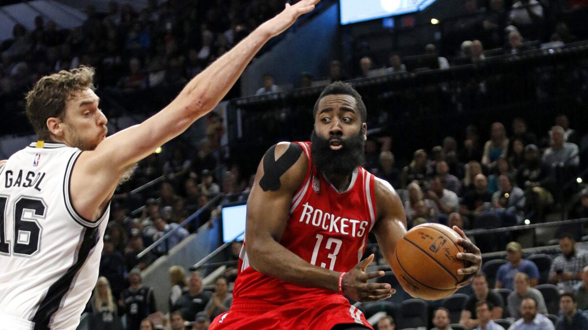 Rockets guard James Harden looks to pass after driving to the basket against Spurs forward Pau Gasol during their game Wednesdsay night.