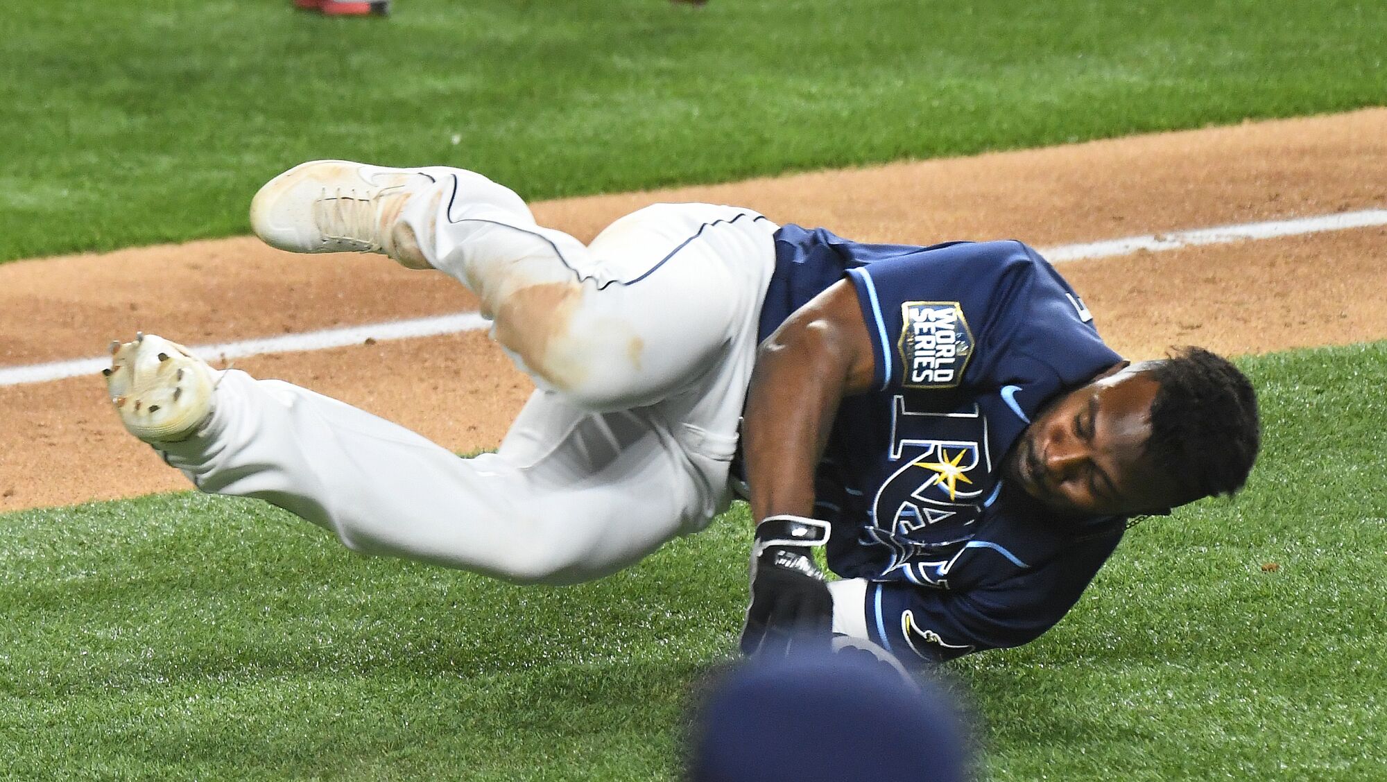 Tampa Bay Rays baserunner Randy Arozarena stumbles and falls between third and home before getting up.
