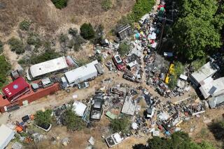 Sunland, CA - June 15: An aerial view of a 9-acre Sunland property owned by Mary Ferrera, 80, of La Crescenta, and occupied by her son David, 50, which has been the subject of years of complaints by neighbors. The owner was sentenced to jail time earlier this year for failure to clean it up. Photo taken in Sunland Saturday, June 15, 2024. Elena Malone and her husband, Josh Ryan, who are school teachers, bought their dream house in a horsey/moutainous area of Sunland. Their neighbor is a hoarder/mentally ill/drug addict who has made life very difficult for a street in Sunland and particularly one family. Next door was a 9 acre property owned by a retired school teacher and occupied by her troubled son, David Ferrera. At first he seemed friendly, but pretty soon his life fell apart and he and his equally troubled girlfriend were living in a car outside Malone's front gate. The property has no electricity or running water. There were stolen cars blocking the street, used condoms, trash bags of marijuana, anal plugs, human waste. The property itself is strewn with stolen cars (LAPD estimates 100 stolen vehicles on property) and unpassable to authorities. At one point Malone needed to pick her husband up from chemotherapy and couldn't get out of her gate. Her children cannot play outside. A judge earlier this year sentenced the elderly mother to jail - she was out in 11 hours - but said he couldn't do anything else and suggested Malone confront Karen Bass. The fire department had cleaned up the street somewhat, but the property itself is still a mess and a fire harzard (There have been several wildfires in this area.) (Allen J. Schaben / Los Angeles Times)