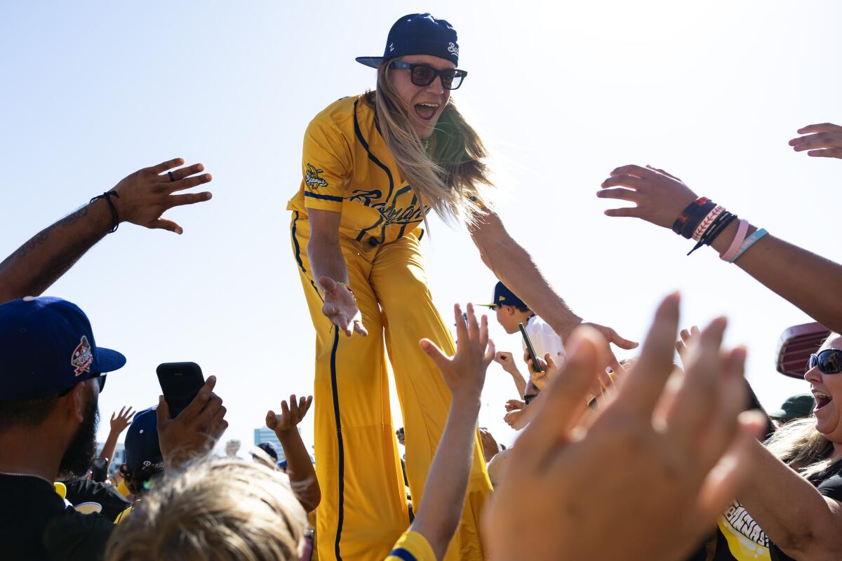 The Savannah Bananas' Dakota Albritton walks on stilts through the crowd outside Angel Stadium.