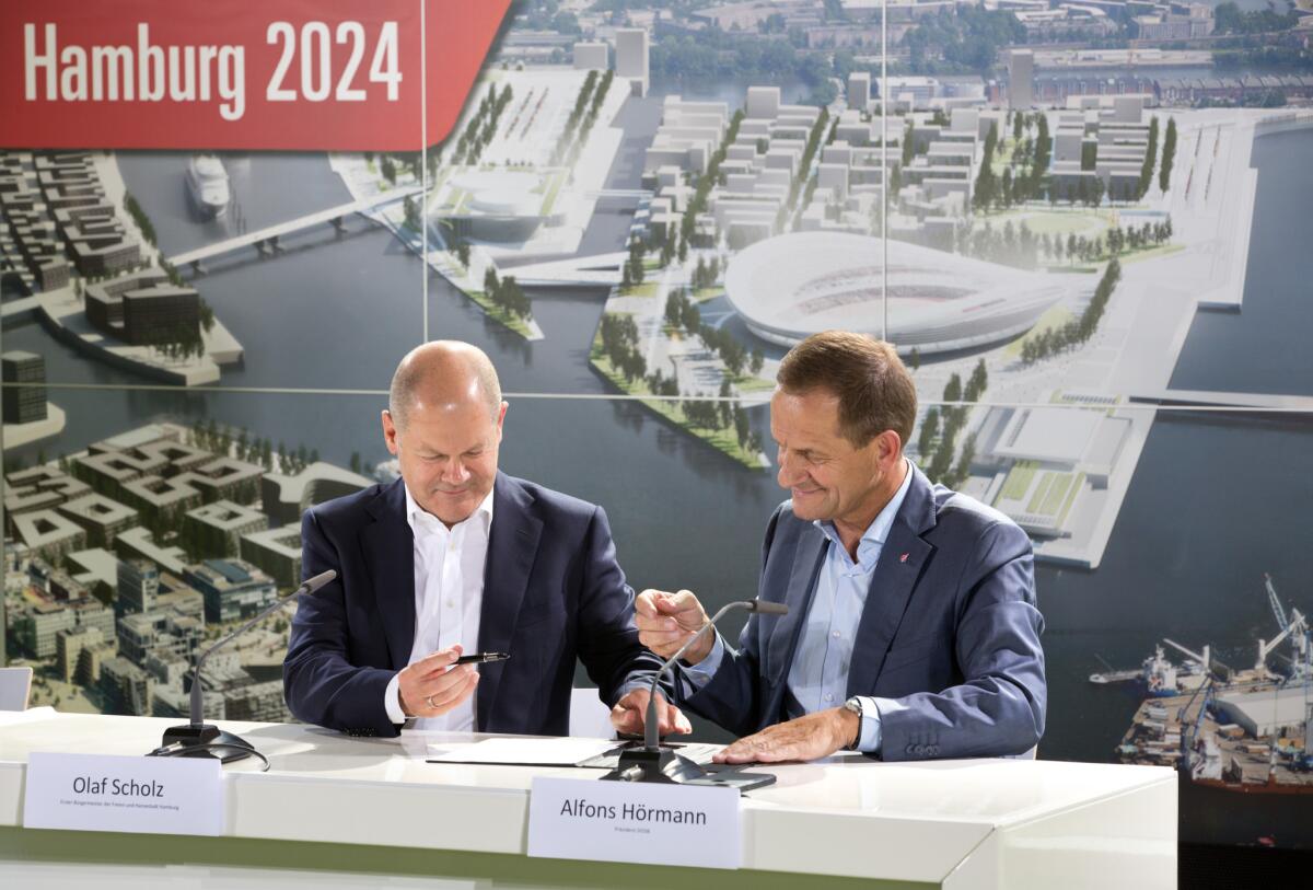 Mayor Olaf Scholz, left, and Alfons Hoermann, president of the German Olympic Sports Confederation, sign Hamburg’s application letter to host the 2024 Olympics.