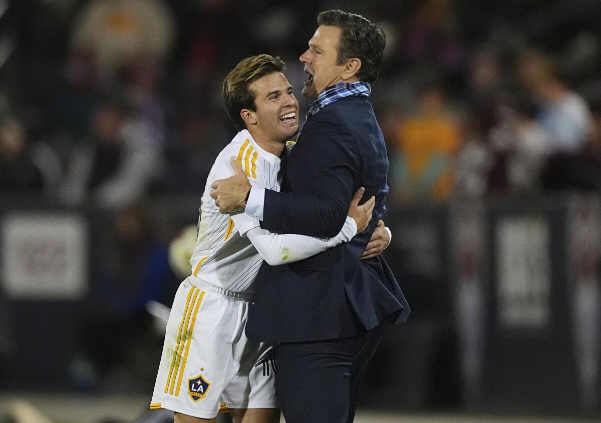 Galaxy coach Greg Vanney hugs midfielder Riqui Puig after scoring two goals in stoppage time during the 2024 playoffs.
