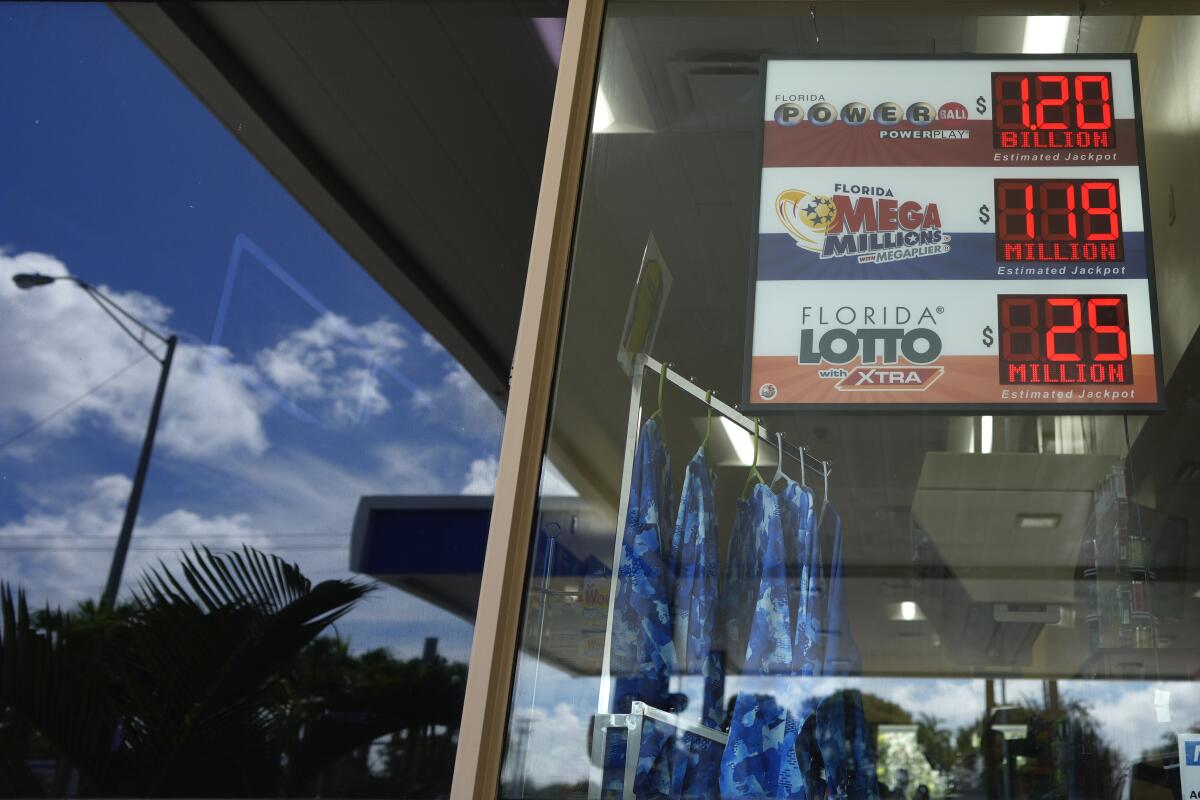 A sign shows the current jackpot for the Powerball lottery, $1.2 billion, as it hangs in the reflective window of a convenience store in Miami, Wednesday, Nov. 2, 2022. The jackpot climbed to $1.2 billion after no one matched all six numbers to win. (AP Photo/Rebecca Blackwell)