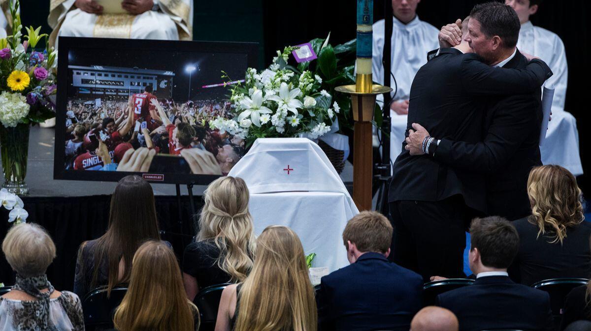 Ryan Hilinski is hugged by his dad Mark Hilinski after he spoke at his brother Tyler Hilinski's funeral at Damien High School on Saturday in La Verne.
