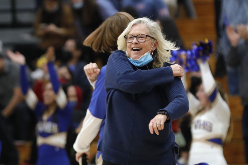 Fountain Valley head coach Marianne Karp celebrates a victory after defeating Corona Del Mar during close girls' Surf League basketball game on Monday.