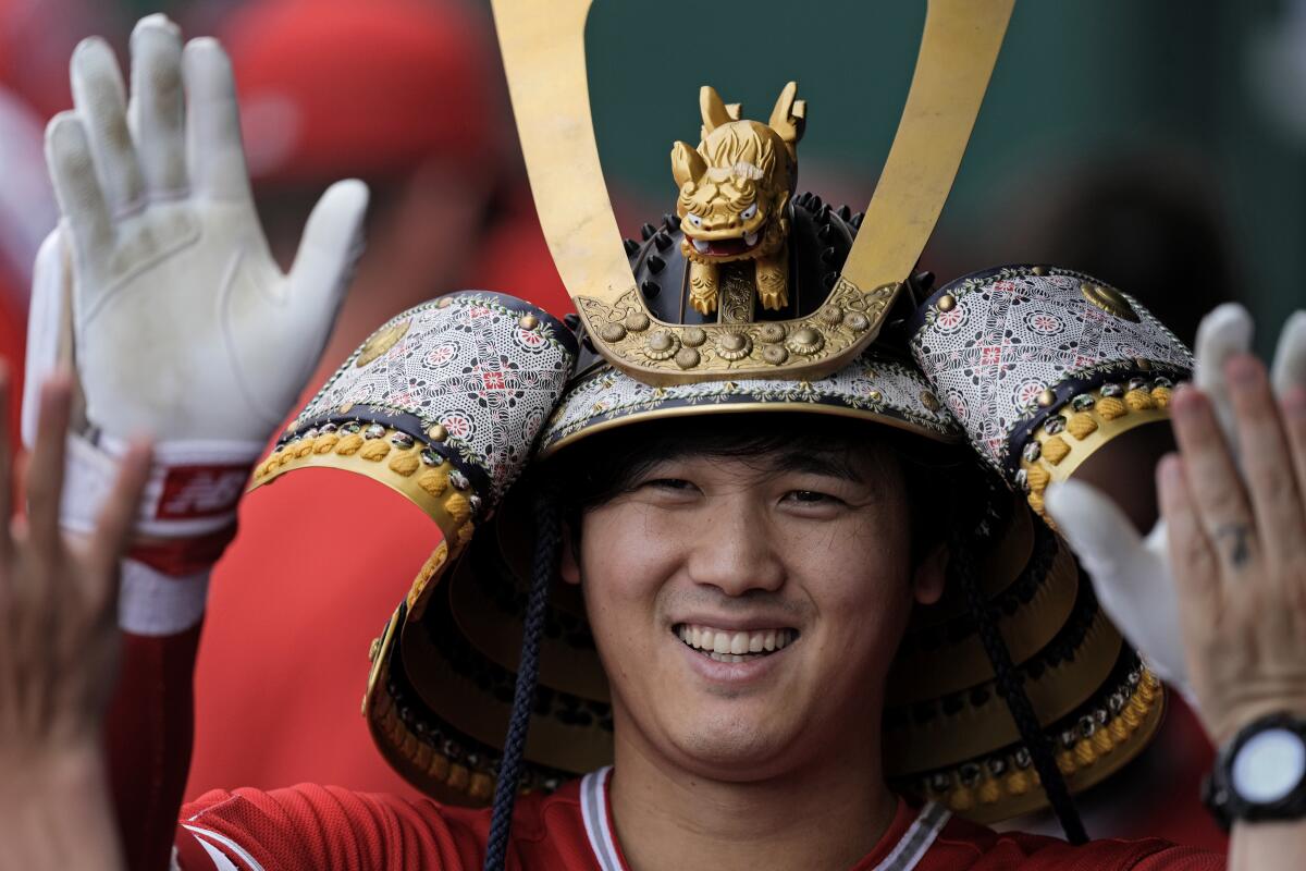 The Angels' Shohei Ohtani celebrates in the dugout after he homered during the seventh inning for career blast No. 150.