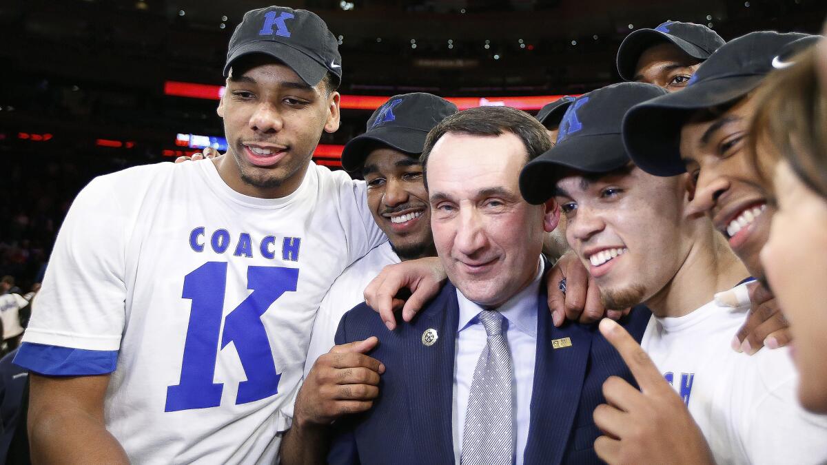 Duke Coach Mike Krzyzewski, center, celebrates with his players after earning his 1,000th career coaching victory Sunday against St. John's.