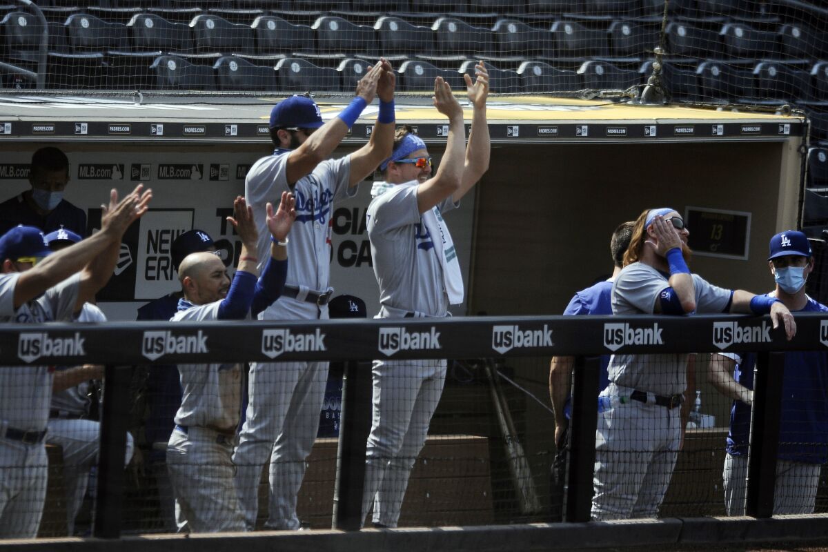 The Los Angeles Dodgers bench claps for Will Smith after he hit a two-run double against the San Diego Padres in the fifth inning of a baseball game Wednesday, Sept. 16, 2020, in San Diego. (AP Photo/Derrick Tuskan)