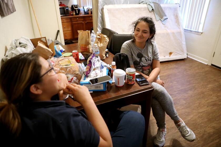LOS ANGELES, CA - MAY 09: Alondra Gordillo, 14, left, and mother Ruby Gordillo, 35, at their home in El Sereno on Monday, May 9, 2022 in Los Angeles, CA. Ruby Gordillo's family became one of more than a dozen that seized empty, state-owned homes in El Sereno that had been left abandoned for a freeway project that never came. Ruby lives there with her husband Miguel Angel Gordillo and three children Michelle Gordillo, 16, Alondra Gordillo, 14, and Jacob Gordillo, 10. Ruby and family previously lived in a studio apartment along Columbia Ave. on the border of Pico-Union. Overcrowded housing in Pico-Union, considered the most overcrowded neighborhood in Los Angeles. (Gary Coronado / Los Angeles Times)
